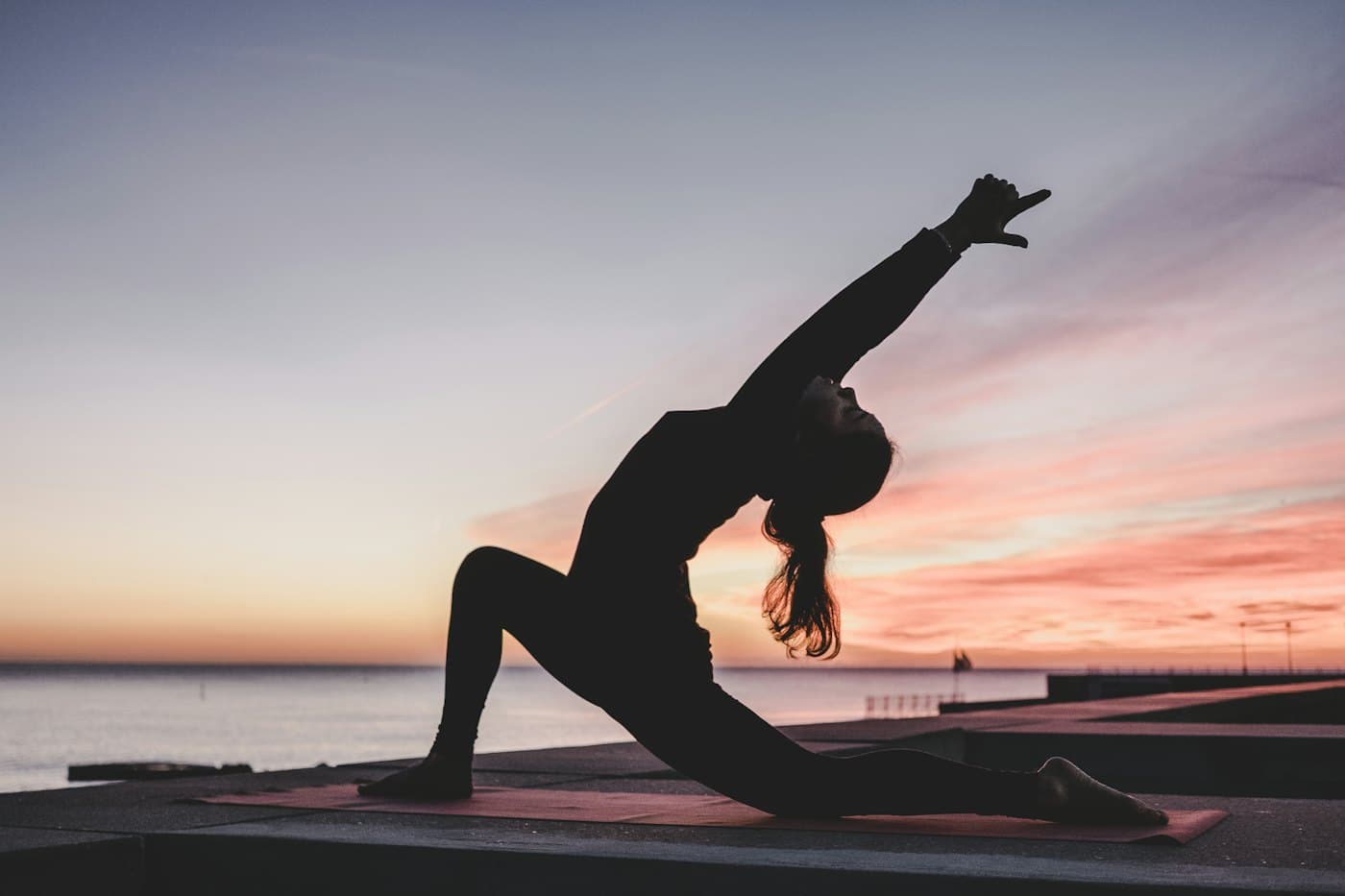 A person holding a yoga pose at sunset
